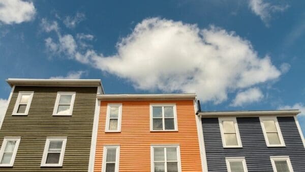 A row of houses with windows and doors against the sky.