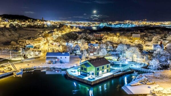 A night time photo of a harbor with boats and buildings.