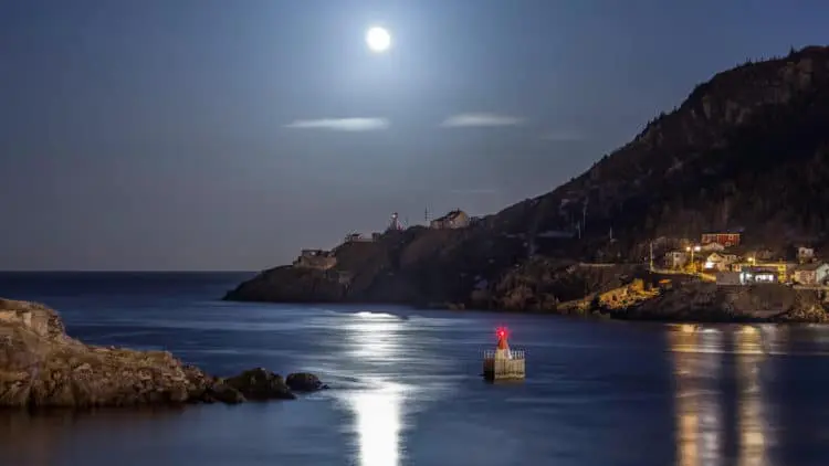 A boat floating on top of the ocean at night.