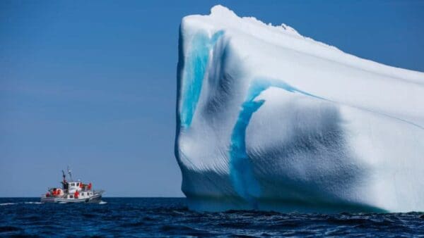 A large blue and white iceberg in the ocean.