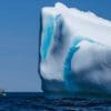 A large blue and white iceberg in the ocean.